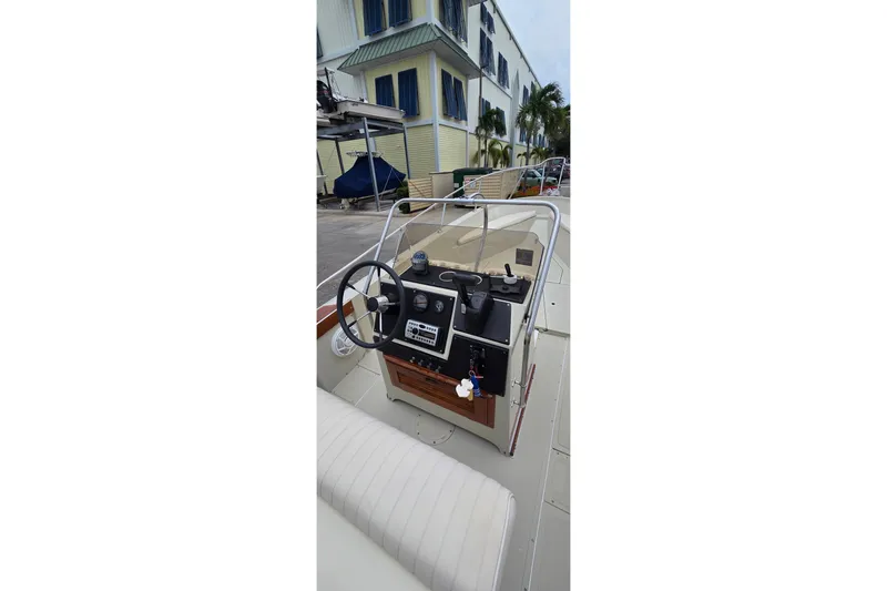 Slide: The Image of 1986 Boston Whaler Outrage 20 boat dashboard with steering wheel and controls. - 14