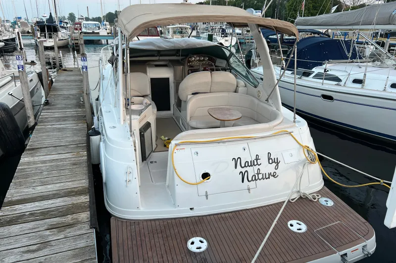 Slide: The Image of 2003 Four Winns 298 Vista boat docked at marina, featuring "Naut by Nature" text. - 5