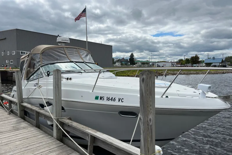 Slide: The Image of 2003 Four Winns 298 Vista boat docked by a wooden pier under cloudy skies. - 8