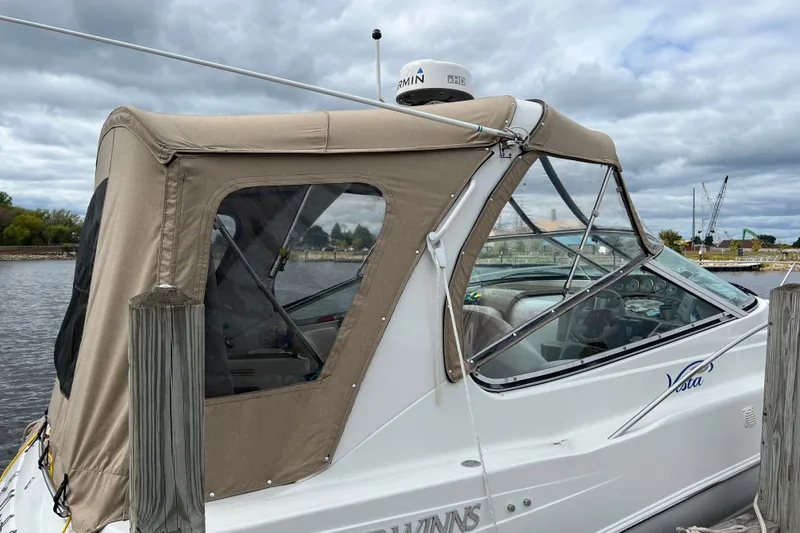Slide: The Image of 2003 Four Winns 298 Vista boat docked with beige canopy under cloudy skies. - 9