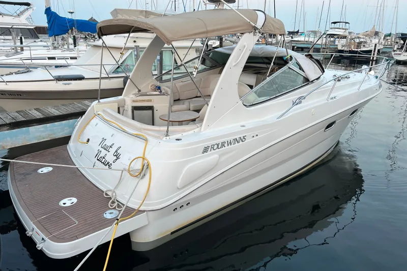 The Image of 2003 Four Winns 298 Vista boat docked at marina, featuring beige canopy and sleek design. - 4
