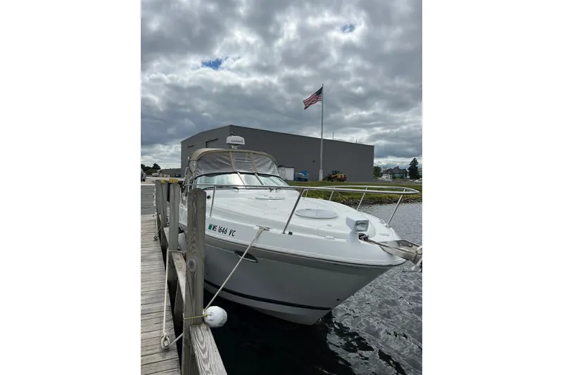 Slide: The Image of 2003 Four Winns 298 Vista boat docked near a marina under cloudy skies. - 7