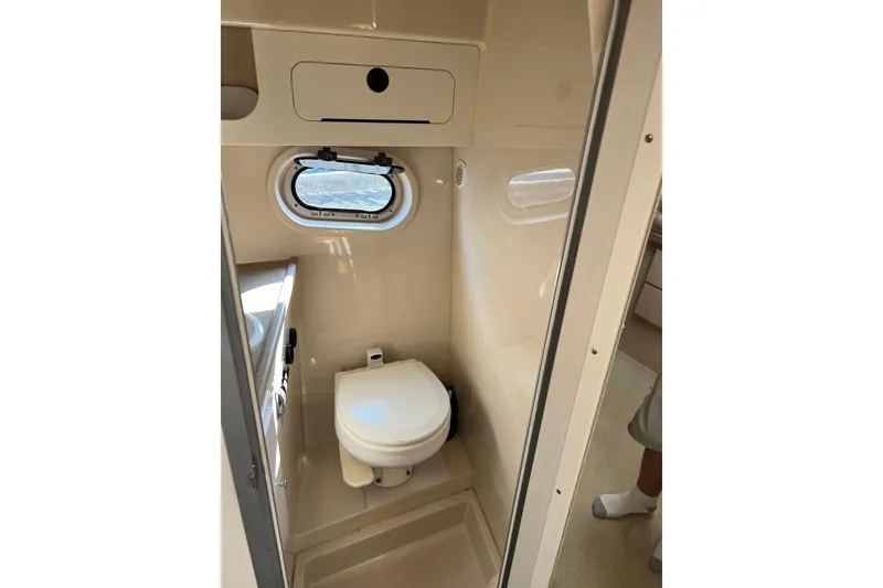 Slide: The Image of 2003 Four Winns 298 Vista boat bathroom with toilet and porthole window. - 24