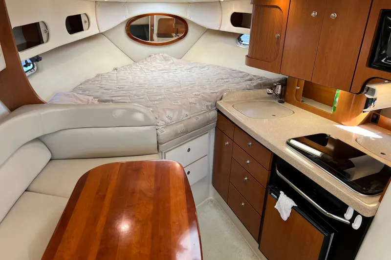 Slide: The Image of Interior of 2003 Four Winns 298 Vista boat with bed, kitchenette, and seating area. - 17