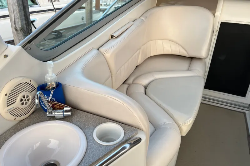 Slide: The Image of Interior of 2003 Four Winns 298 Vista boat with white seating and sink area. - 12