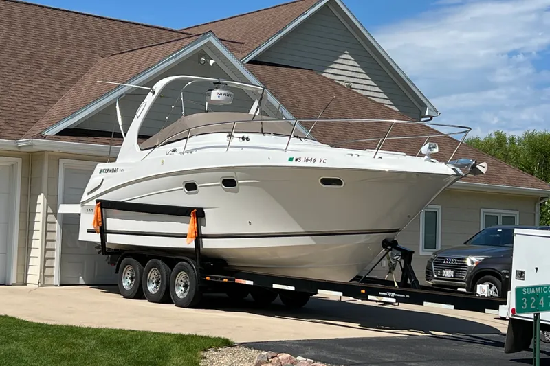 Slide: The Image of 2003 Four Winns 298 Vista boat on trailer in driveway, near house and SUV. - 0