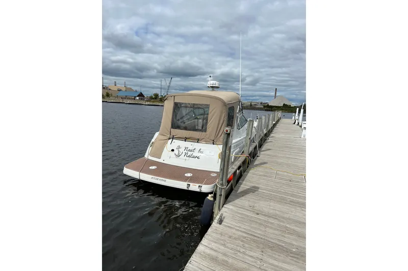 Slide: The Image of 2003 Four Winns 298 Vista boat docked at a marina under cloudy skies. - 6