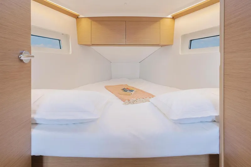 Slide: The Image of Manufacturer Provided Image: 2026 Jeanneau Sun Odyssey 350 cabin with cozy bed and modern wood finish. - 12
