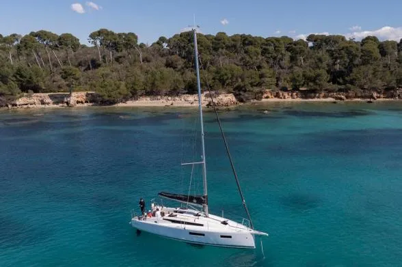 Slide: The Image of Manufacturer Provided Image: 2026 Jeanneau Sun Odyssey 350 sailing in clear turquoise waters near a forested shoreline. - 3