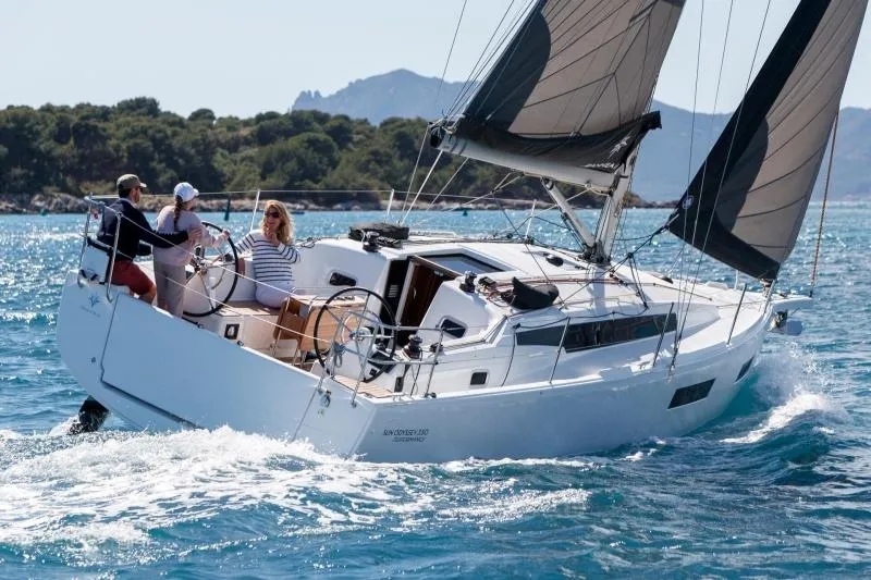 Slide: The Image of Manufacturer Provided Image: 2026 Jeanneau Sun Odyssey 350 sailing on clear blue waters with passengers onboard. - 1