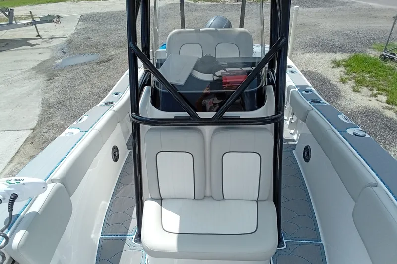 Slide: The Image of 2022 Sea Fox 228 Commander boat interior with seating and console, docked on gravel. - 37