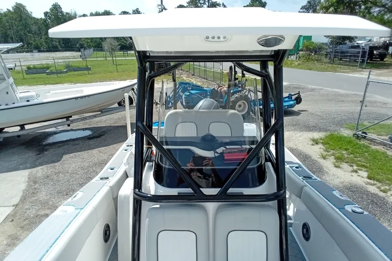 Slide: The Image of 2022 Sea Fox 228 Commander boat with T-top and seating, parked outdoors. - 16