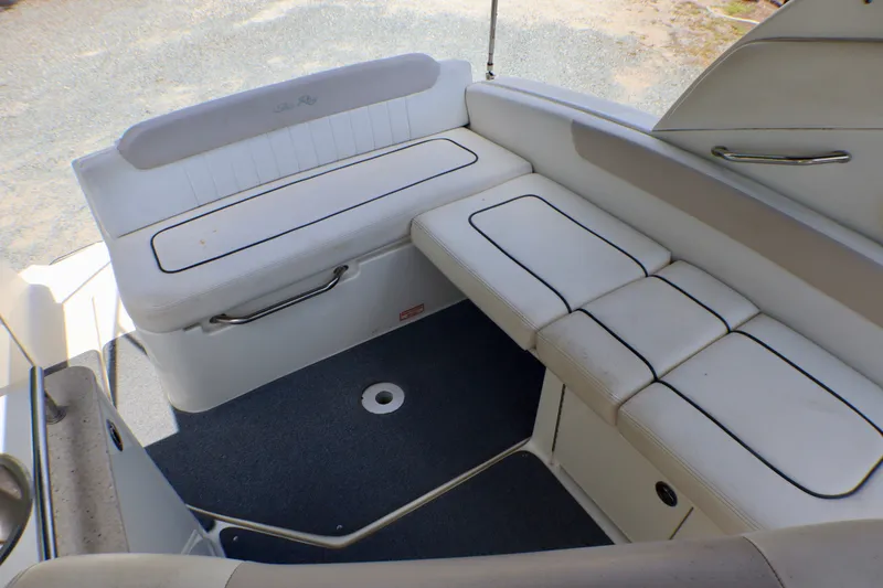 Slide: The Image of 2010 Sea Ray Sundancer 260 boat interior with white cushioned seating and carpeted floor. - 32