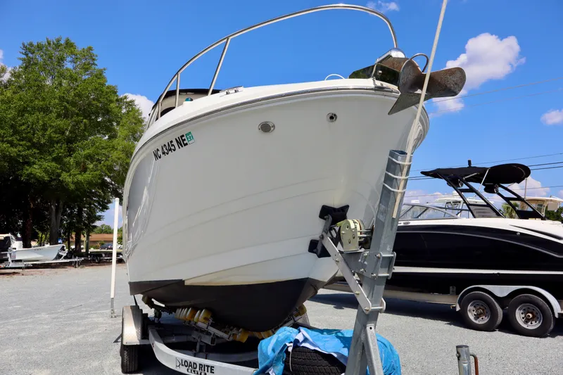 Slide: The Image of 2010 Sea Ray Sundancer 260 boat on trailer, parked outdoors under blue sky. - 7