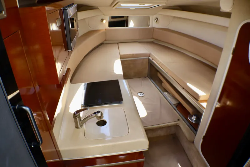 Slide: The Image of Interior of 2010 Sea Ray Sundancer 260, featuring a compact kitchenette and cozy seating area. - 37