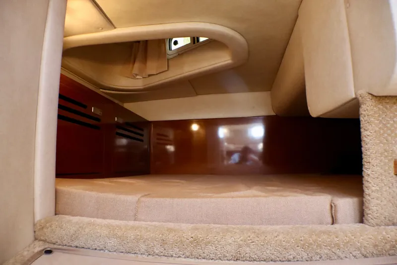 Slide: The Image of Interior cabin of 2010 Sea Ray Sundancer 260, featuring cozy sleeping area and wood accents. - 43