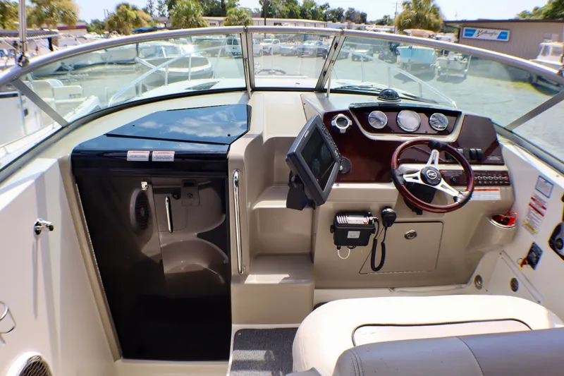 Slide: The Image of 2010 Sea Ray Sundancer 260 cockpit with steering wheel, gauges, and navigation equipment. - 16