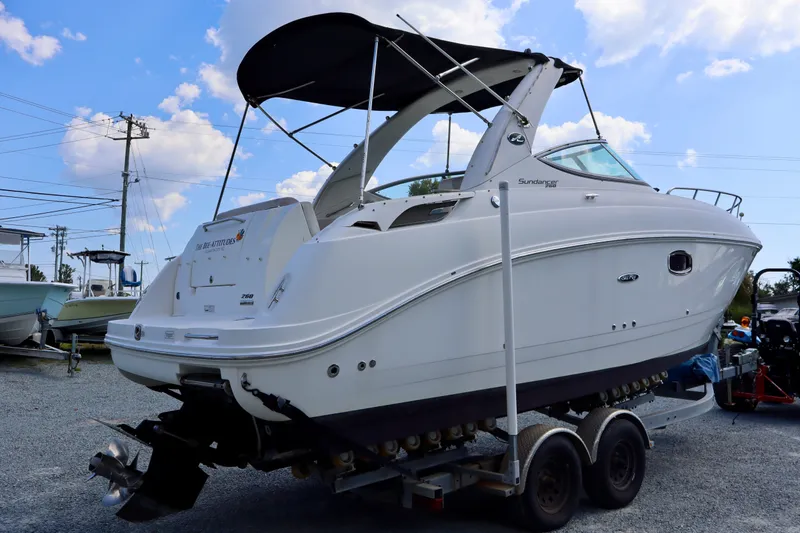 Slide: The Image of 2010 Sea Ray Sundancer 260 boat on trailer, featuring sleek design and black canopy. - 1