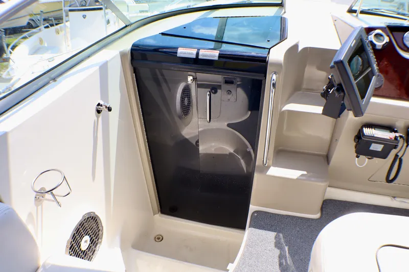 Slide: The Image of 2010 Sea Ray Sundancer 260 cockpit with control panel and cabin door. - 24