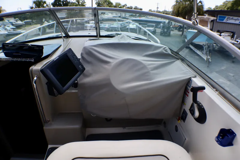Slide: The Image of Interior view of a 2010 Sea Ray Sundancer 260 boat cockpit with covered controls. - 9