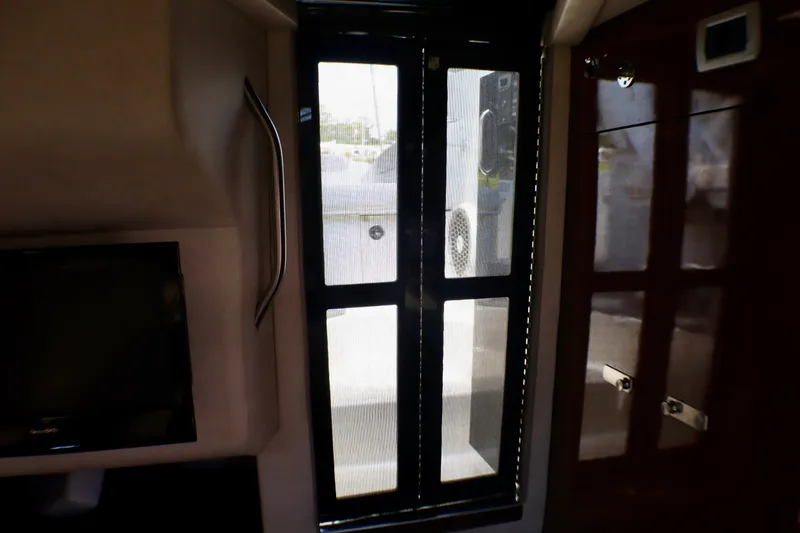 Slide: The Image of Interior view of 2010 Sea Ray Sundancer 260, featuring a window and sleek cabinetry. - 47