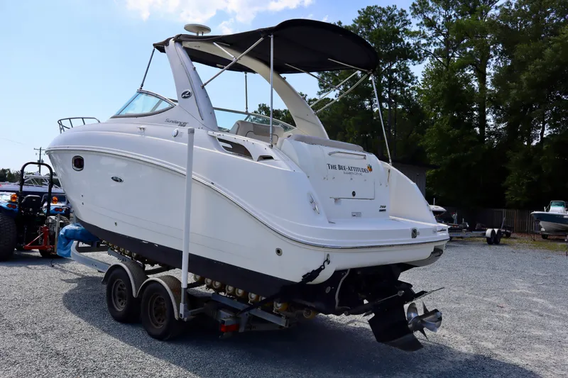 Slide: The Image of 2010 Sea Ray Sundancer 260 boat on trailer, parked outdoors, with canopy and sleek design. - 3