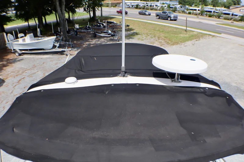 Slide: The Image of 2010 Sea Ray Sundancer 260 boat with black cover, parked outdoors. - 20