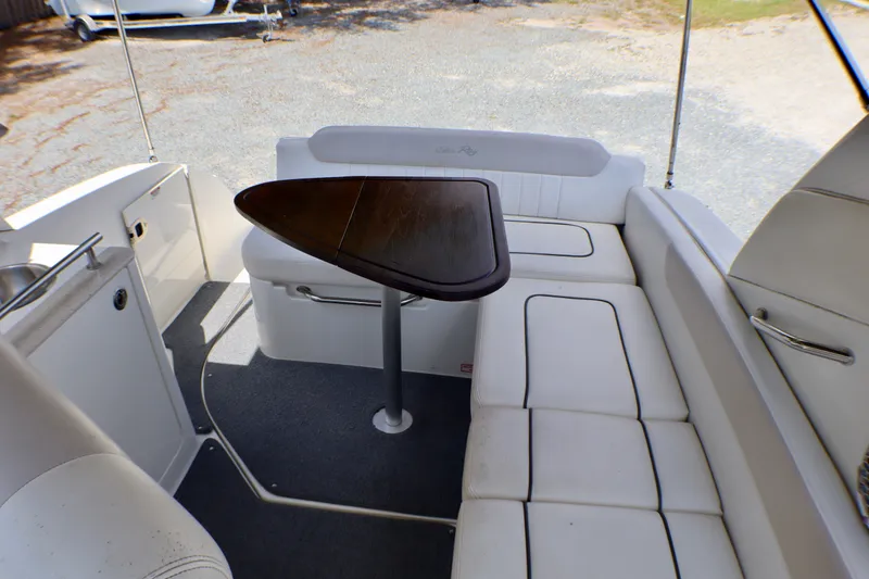 Slide: The Image of Interior of 2010 Sea Ray Sundancer 260 with white seating and wooden table. - 33