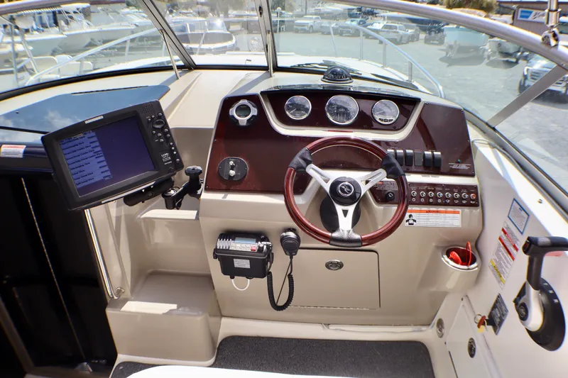 Slide: The Image of Cockpit of 2010 Sea Ray Sundancer 260 with steering wheel and navigation equipment. - 12