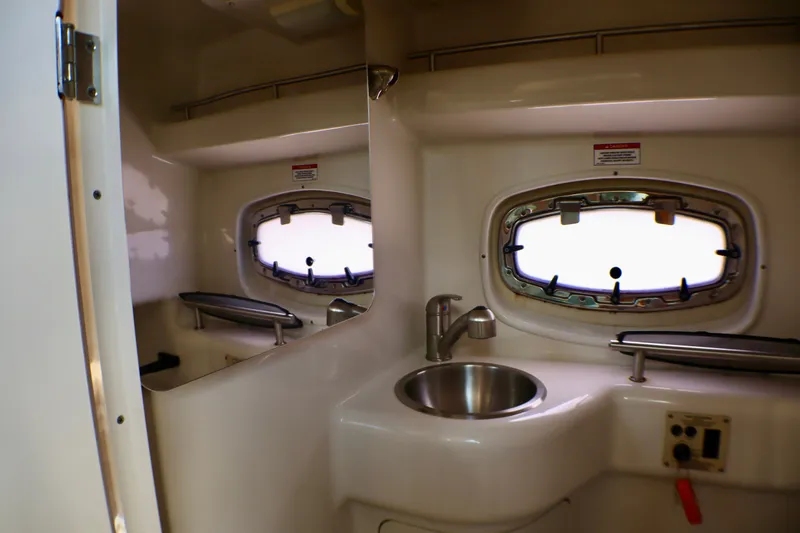 Slide: The Image of Interior of 2010 Sea Ray Sundancer 260 boat, featuring a compact sink and porthole window. - 45
