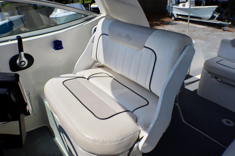 Slide: The Image of 2010 Sea Ray Sundancer 260 boat interior with white cushioned seating. - 26