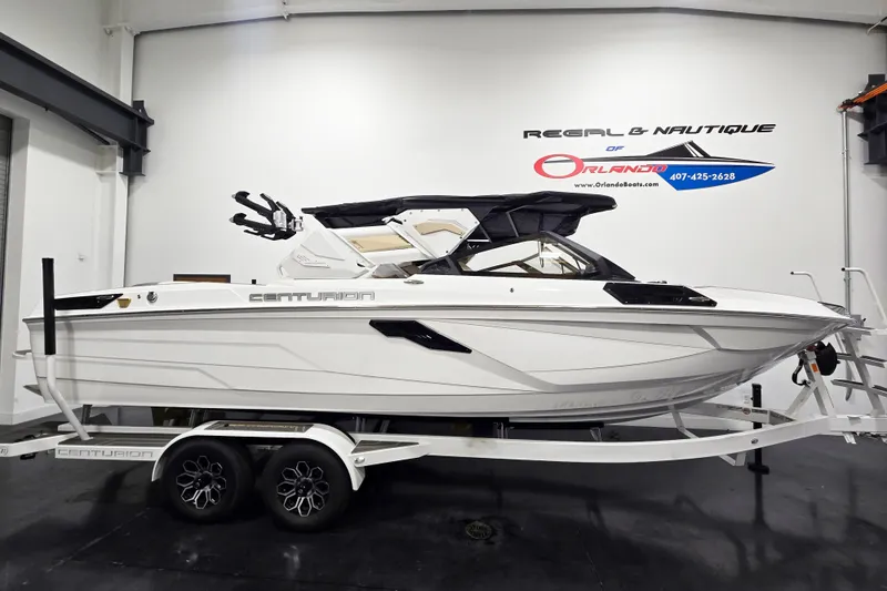 The Image of 2026 Centurion Ri245 boat on trailer in showroom, side view. - 1