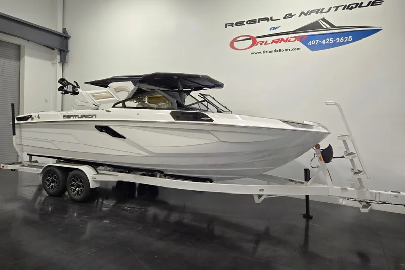 Slide: The Image of 2026 Centurion Ri245 boat on trailer in showroom, featuring sleek design and modern aesthetics. - 2