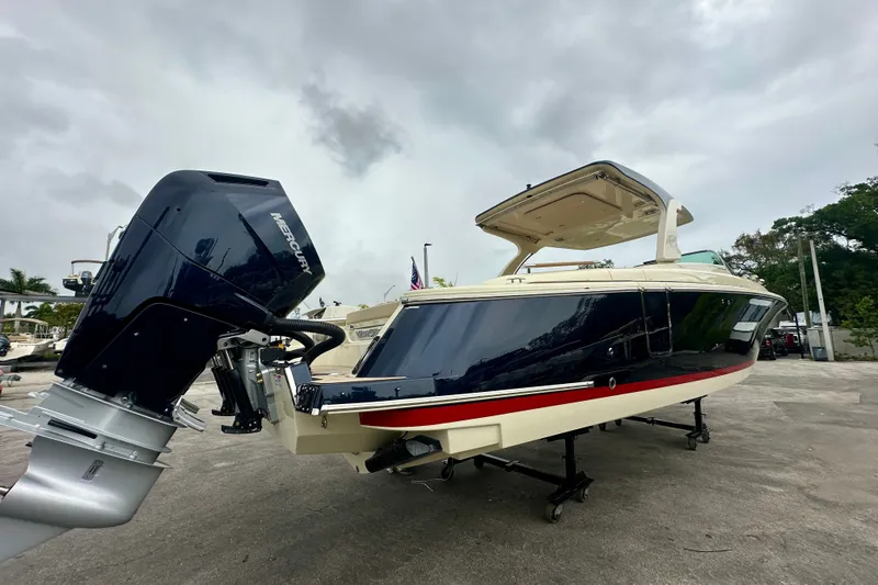 Slide: The Image of 2026 Chris-Craft Launch 35 GT boat with Mercury outboard engine, docked under cloudy skies. - 1