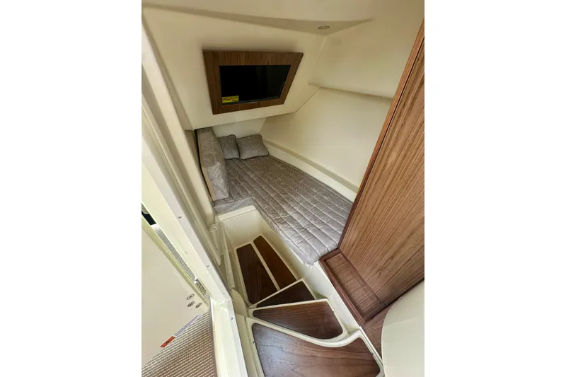Slide: The Image of 2026 Chris-Craft Launch 35 GT cabin interior with bed and TV, featuring wood accents. - 23