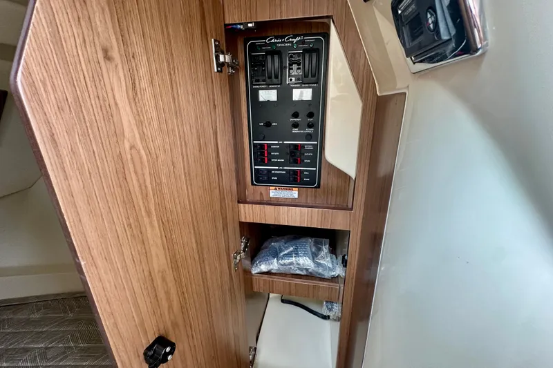 Slide: The Image of 2026 Chris-Craft Launch 35 GT electrical panel with wooden cabinet interior. - 24