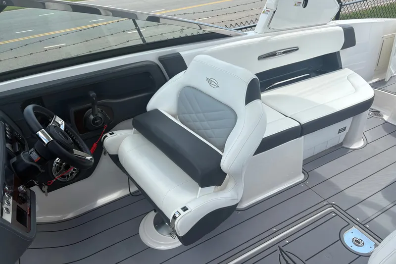 Slide: The Image of 2022 Chaparral 307 SSX boat interior with sleek white seating and modern steering console. - 9