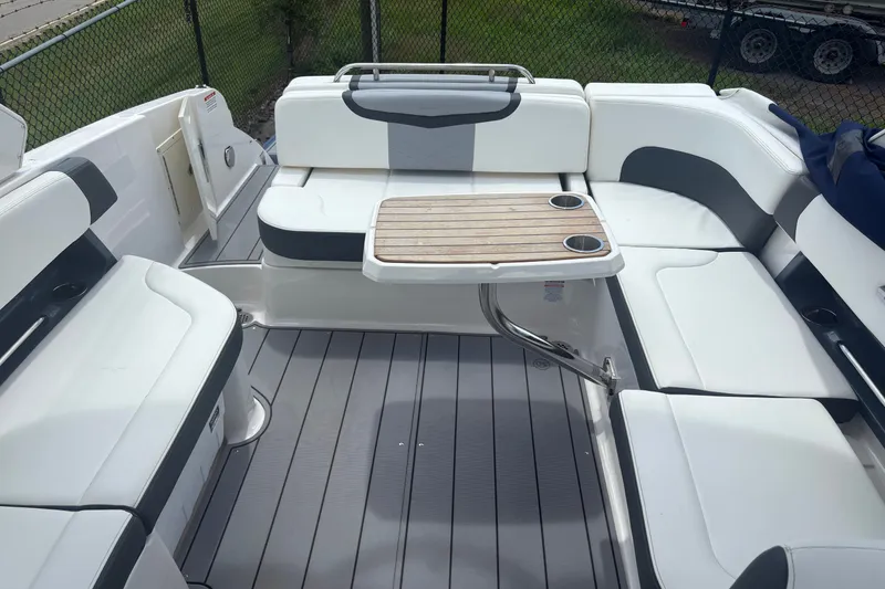 Slide: The Image of 2022 Chaparral 307 SSX boat interior with white seating and wooden table. - 10