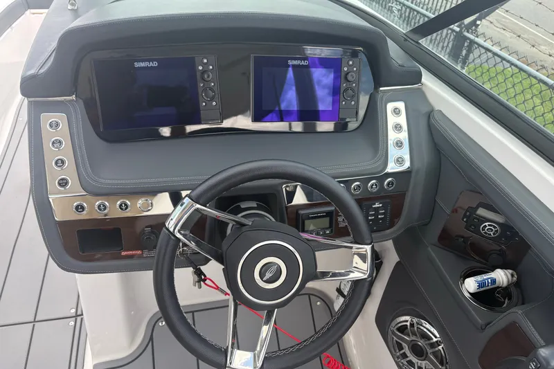 Slide: The Image of 2022 Chaparral 307 SSX boat dashboard with dual Simrad displays and steering wheel. - 13