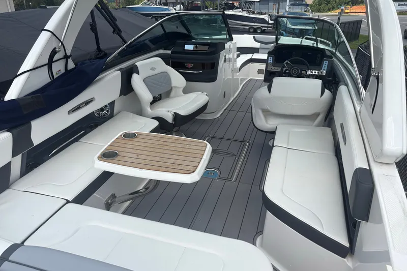 Slide: The Image of 2022 Chaparral 307 SSX boat interior with seating and wooden table. - 11