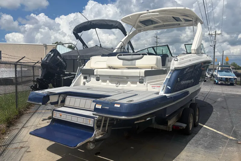 The Image of 2022 Chaparral 307 SSX boat on trailer, rear view, sunny day, dealership lot. - 0