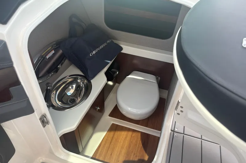 Slide: The Image of 2022 Chaparral 307 SSX boat interior with compact bathroom and sink. - 8