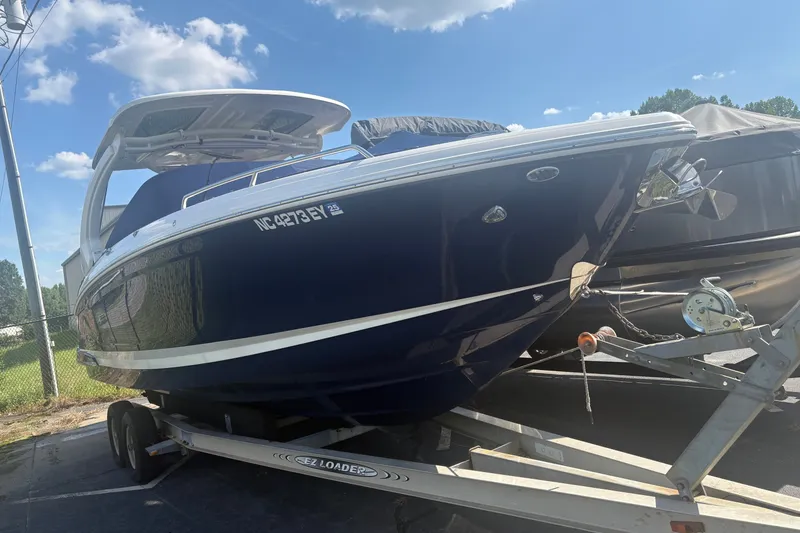 Slide: The Image of 2022 Chaparral 307 SSX boat on trailer under blue sky. - 2