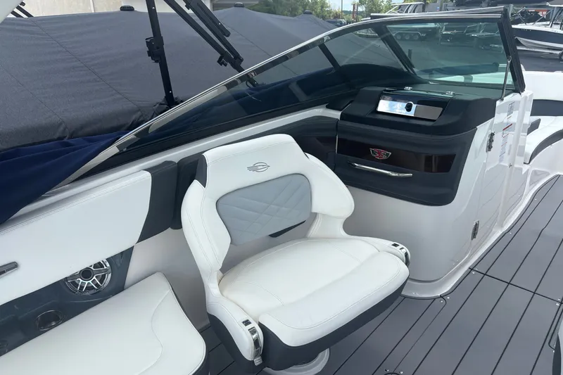 Slide: The Image of 2022 Chaparral 307 SSX boat interior with white seating and sleek dashboard design. - 7