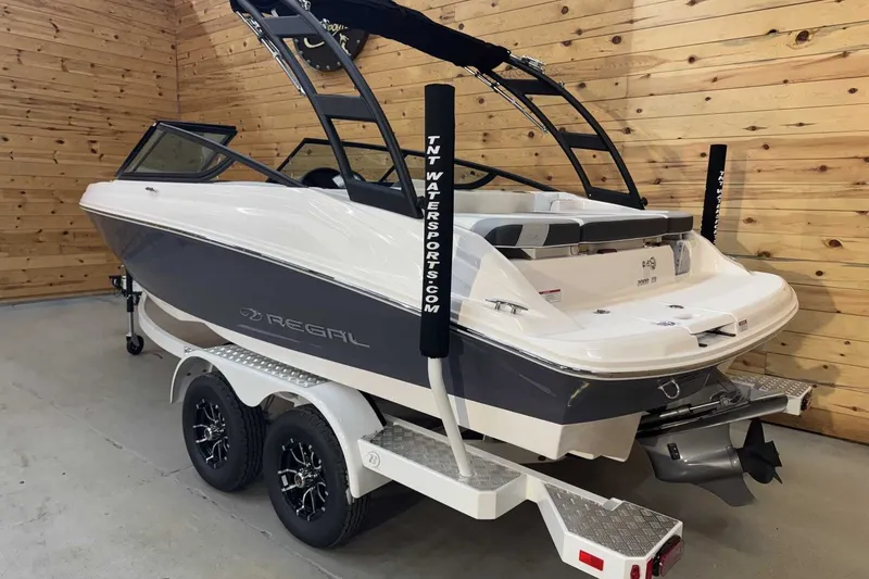 Slide: The Image of 2025 Regal 2000 ES boat on trailer in wooden interior setting. - 2