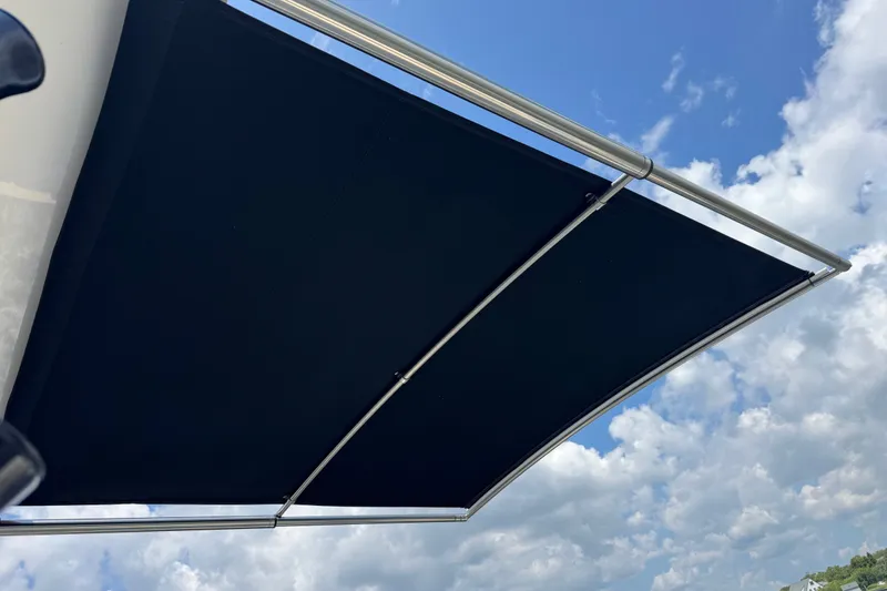 Slide: The Image of Boston Whaler 325 Conquest 2023 boat canopy against a blue sky with clouds. - 16