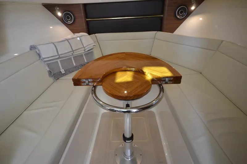 Slide: The Image of Manufacturer Provided Image: 2023 Boston Whaler 325 Conquest cabin with wooden table and white seating. - 20