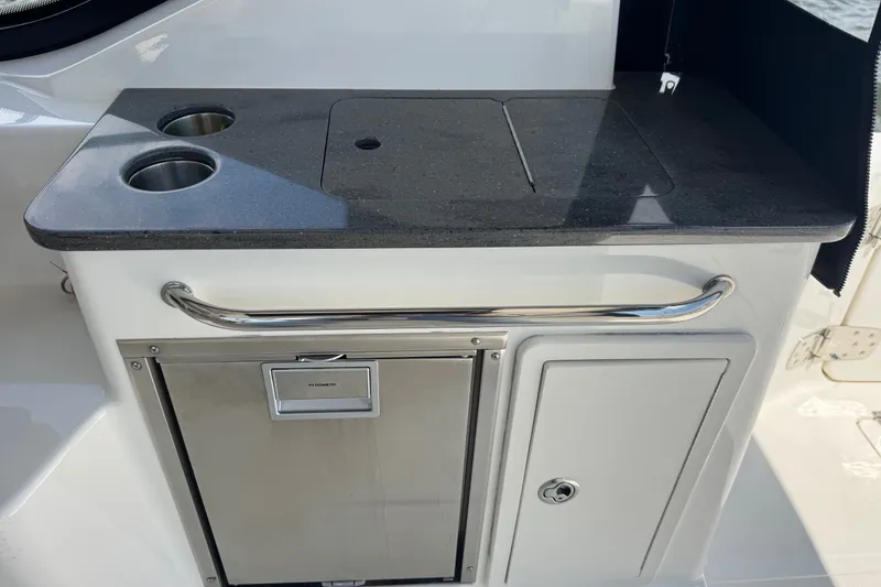 Slide: The Image of 2023 Boston Whaler 325 Conquest boat kitchenette with stainless steel fixtures and storage compartments. - 13