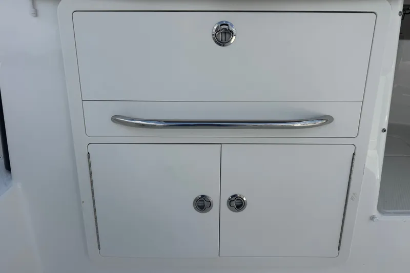 Slide: The Image of Storage compartment on a 2023 Boston Whaler 325 Conquest boat, featuring sleek design and chrome handles. - 15