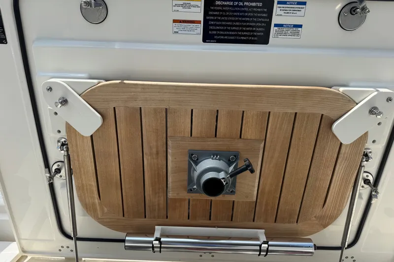 Slide: The Image of 2023 Boston Whaler 325 Conquest boat deck with wooden panel and metal fittings. - 28